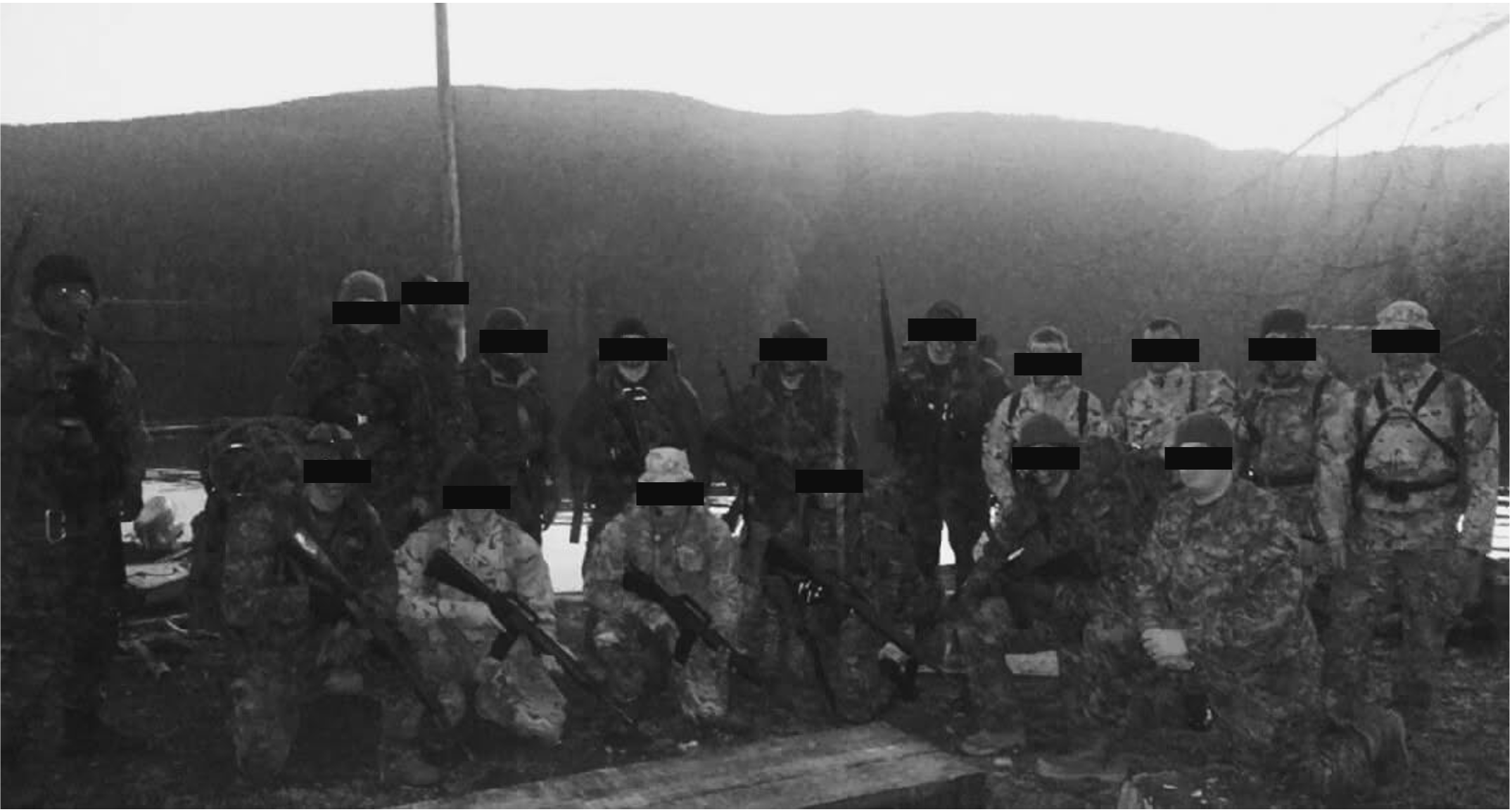 Troop photo at dawn after a field exercise, eyes redacted. Bradley Hartwick stands at far left, circled.
